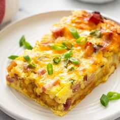 a slice of quiche on a plate with green onions and garnishes