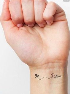 a woman's arm with a small tattoo on it that says believe and a bird