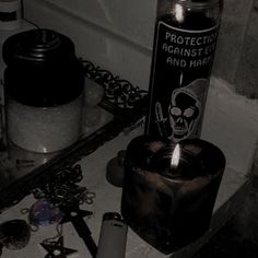 there is a candle that is on the counter next to some bottles and other items