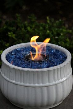 an outdoor fire pit with blue glass pebbles