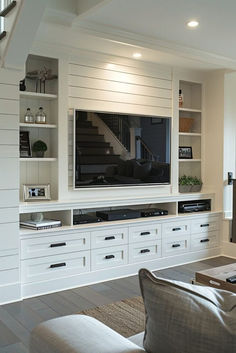 a living room filled with furniture and a flat screen tv on top of a wall