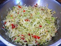 a metal bowl filled with shredded vegetables on top of a table