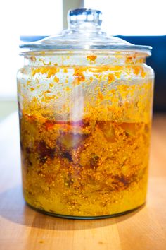 a glass jar filled with food sitting on top of a wooden table