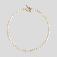 Indulge in effortless elegance with the La Ola Pearl Collar, a modern take on a classic heirloom. Cultured freshwater pearls are strung and hand-knotted in ivory silk string, resulting in a luxurious and timeless piece. The collar is finished with a hand-carved mixed metal toggle clasp made of high-quality 925 sterling silver and 2.5 microns 18ct gold vermeil, adding to its sophisticated and refined appeal. Wear the La Ola Pearl Collar alone for a classic and elegant look, or combine it with oth Classic Single Strand Necklace For Everyday, Classic Single Strand Necklace For Everyday Luxury, Elegant White Toggle Necklace With Pearl Charm, Classic Everyday Single Strand Pearl Necklace, Minimalist Single Strand Pearl Necklace For Formal Occasions, Classic Single Strand Pearl Necklace For Everyday, Elegant Gold Pearl Toggle Necklace, Gold Pearl Elegant Toggle Necklace, Elegant Single Strand Pearl Necklace