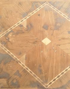 a wood floor that has been stained brown with white lines and holes in the center