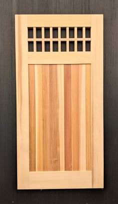 a wooden wall with a small window in the center and some bars on it's side