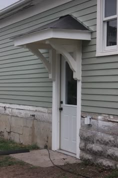 a house with a white front door and an awning on the side of it