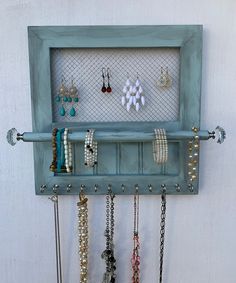 a wall mounted jewelry rack with several pairs of earrings