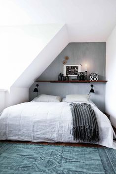 a white bed sitting under a slanted ceiling