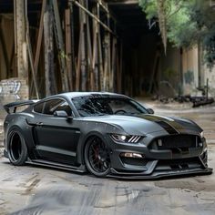 a grey mustang with black stripes parked in an alley