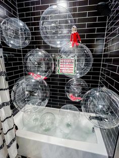 the bathtub is filled with clear bubbley balls and an elf figurine