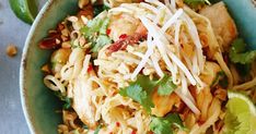 a bowl filled with noodles, meat and cilantro on top of a table