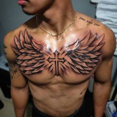 a man with tattoos on his chest and wings