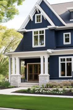 a large blue house with white trim and two story windows on the second floor is shown