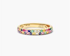 a yellow gold ring with multicolored stones on the inside, and an inscription that reads