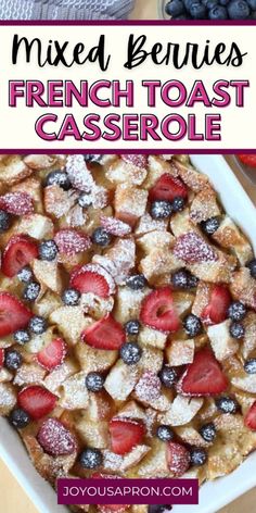 mixed berries french toast casserole with powdered sugar on top in a white dish