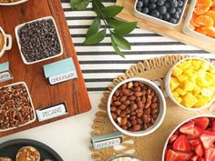 an assortment of fruit and nuts displayed in bowls