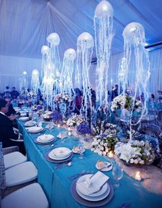 the table is set with plates and place settings for an elegant dinner in blue hues