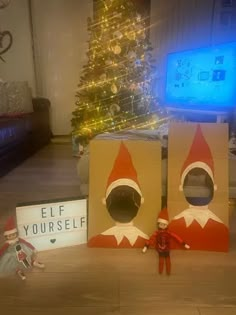 two elf boxes sitting on the floor next to a christmas tree