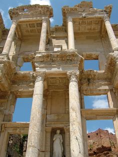 an ancient building with columns and a statue