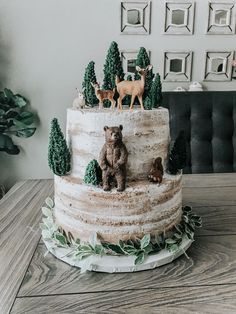 a three tiered cake with bears and deer figurines sitting on top of it