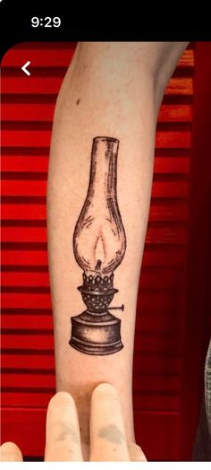 a tattoo on the arm of a person with a light bulb in front of it