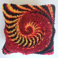 a red and yellow decorative pillow on a white background