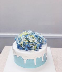 a blue and white cake with flowers on top