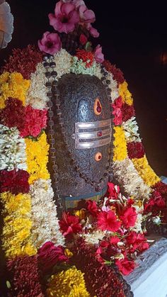 an elaborately decorated mask with flowers around it