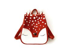 a small red and white purse with polka dots on it's face, hanging from the side