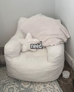 a white bean bag chair sitting on top of a wooden floor next to a wall