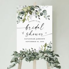 a sign with greenery on it that says, welcome to the bridal shower