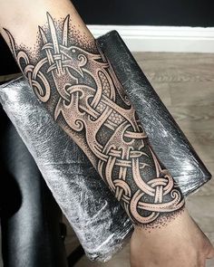 a man's arm with an intricate tattoo design on the forearm and hand,