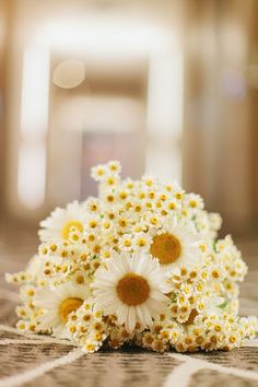 a bouquet of daisies sitting on top of a table next to the words bonn dia