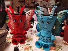 three colorful vases sitting on top of a table covered in paper mache art