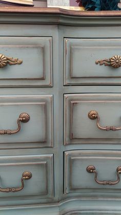 an old dresser has been painted blue with gold handles and knobs on the drawers