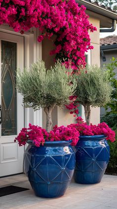 two large blue vases filled with pink flowers