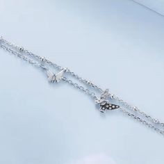 Add a touch of elegance to your style with our Butterflies double chain bracelet! Made from high-quality sterling silver, this bracelet features delicate butterfly charms that will flutter on your wrist. Perfect for any occasion, it's a must-have accessory for any butterfly lover. Materials: 925 sterling silver, cubic zirconiaFinish: platinum plateChain length: 6 in + 2 in adjustable chain Jewelry Care: See more information about how to care for your jewelry here. Shipping Policy: Orders will be shipped within 1-3 business days. Economy shipping will take 7-14 days to arrive and standard shipping is 1- 4 days for U.S. orders. International shipping time is depended on the country and per shipping method. Shipping cost will be calculated at check out.For more details, see our Shipping Polic Silver Dainty Butterfly Bracelets, Delicate Sterling Silver Charm Bracelet, Dainty Silver Butterfly Bracelets, Trendy Adjustable Silver Butterfly Necklace, Silver Adjustable Charm Bracelet With Butterfly, Adjustable Silver Charm Bracelet With Butterfly, Sterling Silver Butterfly Bracelets, Elegant Silver Charm Bracelet With Butterfly Charm, Sterling Silver Butterfly Bracelet