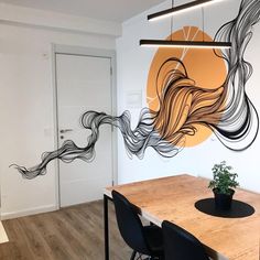 a dining room table with chairs and a painting on the wall behind it that looks like waves