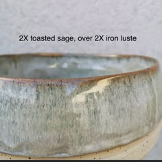 a close up of a bowl on a table with the words 2x toasted sage over 2x iron luste