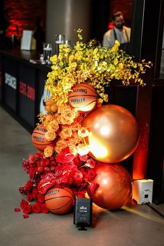 an arrangement of basketballs and flowers on display