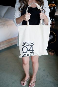 a woman holding a white bag with the number forty four on it in front of her