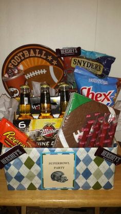 a football themed gift basket with beer, snacks, and sports memorabilia on a table