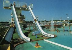 the water park is filled with people enjoying it's waterslides and slides