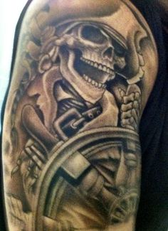 a man with a skull and steering wheel tattoo on his arm