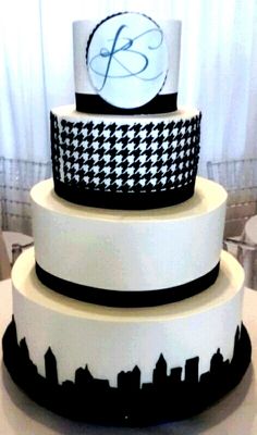 a three tiered cake with black and white designs