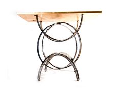 a table that is made out of metal and wood with an oval design on the top