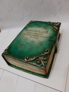 a green book cake sitting on top of a table