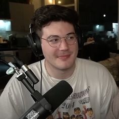 a man wearing headphones sitting in front of a microphone