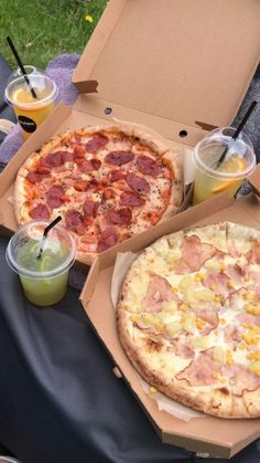 two pizzas and drinks are sitting on the table in front of an open box